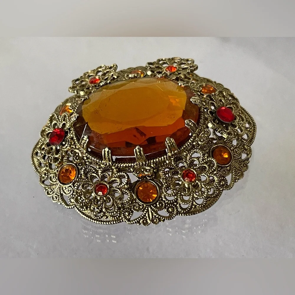 Vintage West Germany brooch featuring a large amber topaz glass filigree gold